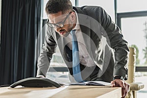 angry adult businessman shouting at speakerphone