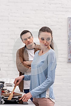 angry adult man looking at wife while she ignoring him after argument