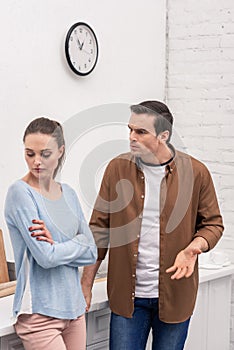 angry adult man looking at wife while she ignoring him after quarrel