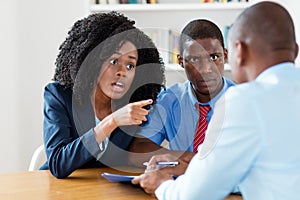 Angry african american couple rejecting offer of real estate agent