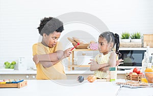 Angry african brother and little sister madly looking at each other with arms crossed gesture while playing toys together at home