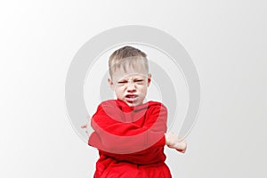 Angry aggressive boy indignant at camera. Child in a red hoodie is expressing anger. Excitement and frown