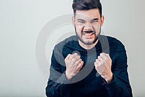 Angry aggressive man shouting out loud with ferocious expression