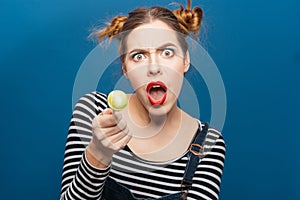 Angry amazed young woman with lollipop shouting