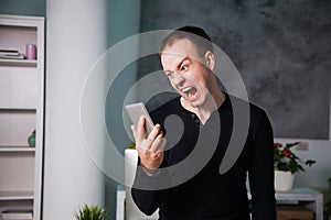 Angry annoyed man talking by phone, shouting guy