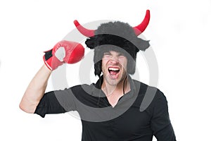 Angry as bull. Man shouting face wears hat of devil or bull with horns. Guy black shirt angry aggressive demonstrate