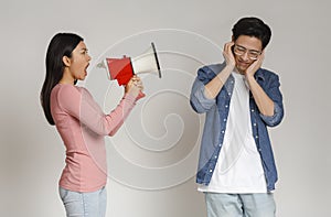 Angry asian girl shouting through megaphone at her boyfriend