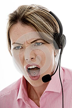 Angry Attractive Young Business Woman Using a Telephone Headset