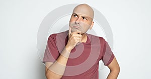 Angry bald man is looking up and thinking about a problem