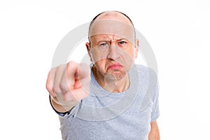 Angry baldheaded man pointing in to the camera and smiling