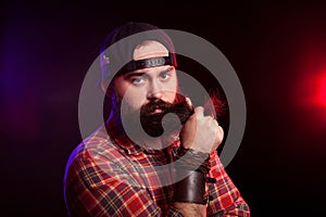 Angry bearded hipster man holding his beard in hands