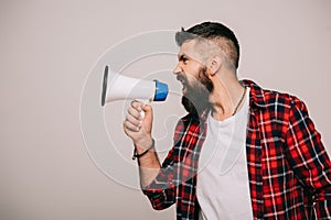 Angry bearded man in checkered shirt screaming into megaphone, isolated photo
