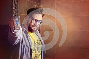 Angry bearded worker in protective glasses holds a heavy hammer in front of him with the intention of teaching someone a lesson