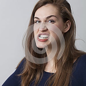 Angry beautiful 20s girl grinding her teeth threatening photo