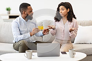 Angry black husband blaming his wife for wasting money