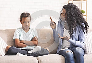 Angry black mom scolding naughty little daughter at home