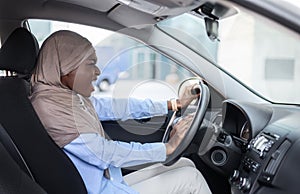 Angry Black Muslim Businesswoman Driving Car, Stuck In Traffic, Emotionally Beeping Horn photo