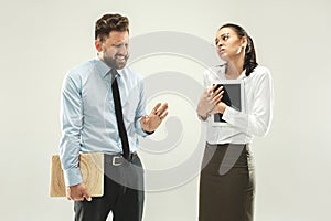 Angry boss. Man and his secretary standing at office or studio