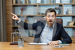 Angry boss shouts at the camera to the employee points his finger to the side dismisses the subordinate, a businessman