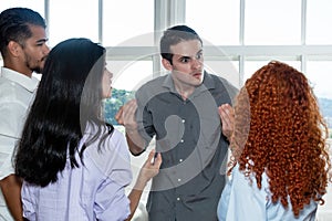 Angry boss talking with lazy employee in team