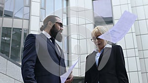 Angry boss throwing papers in front of confused secretary, dissatisfactory work