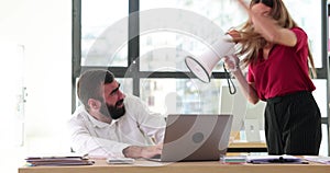 Angry boss woman screaming at man through loudspeaker in office