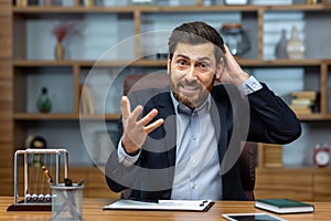 Angry boss yelling at camera, mature senior man working inside office, businessman in business suit with laptop nervous