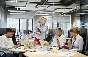 Angry boss yelling at her co-workers photo