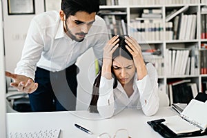 Angry boss yelling at his employee in office