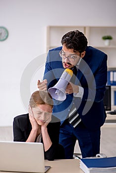 Angry boss and young female employee at workplace