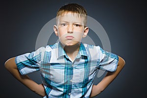 Angry boy isolated on gray background. Closeup