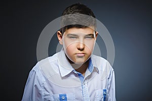 Angry boy isolated on gray background. Closeup