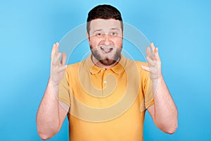 Angry brunette man screaming, rage and mad expression. Isolated on blue background