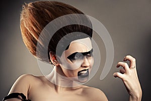 Angry brunette woman with dark makeup and lush hairdo