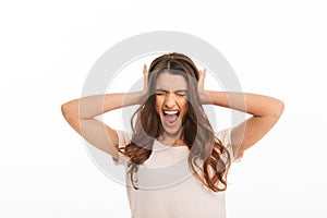 Angry brunette woman in t-shirt screaming with closed eyes