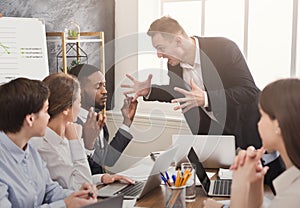 Angry business man screaming at employee in office