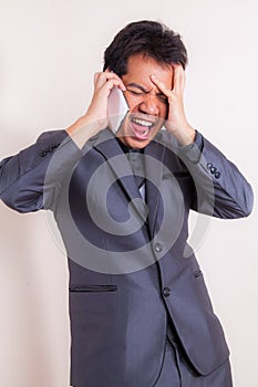 Angry business man yelling at mobile phone