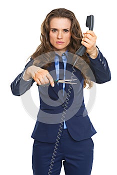 Angry business woman cutting phone wire