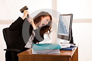 Angry business woman expressing rage at her desk in the office