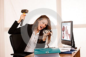 Angry business woman expressing rage at her desk in the office