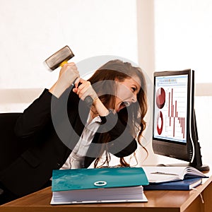 Angry business woman expressing rage at her desk in the office