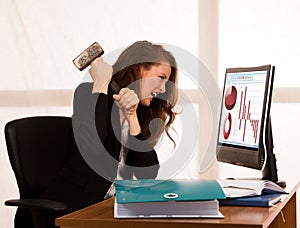 Angry business woman expressing rage at her desk in the office