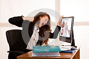 Angry business woman expressing rage at her desk in the office