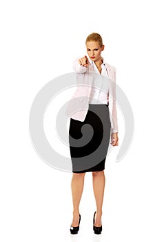 Angry business woman pointing at camera