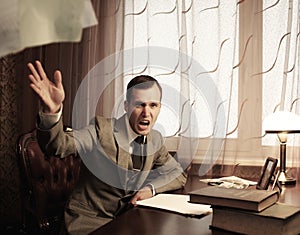 Angry businessman behind table