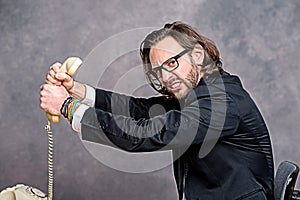 Angry businessman is choking his phone