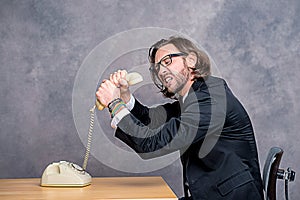 Angry businessman is choking his phone