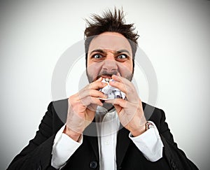 Angry businessman while eating balled pape