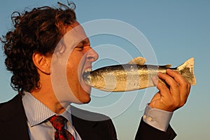 Angry businessman eating fish