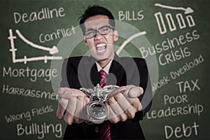 Angry businessman with hands chained at class